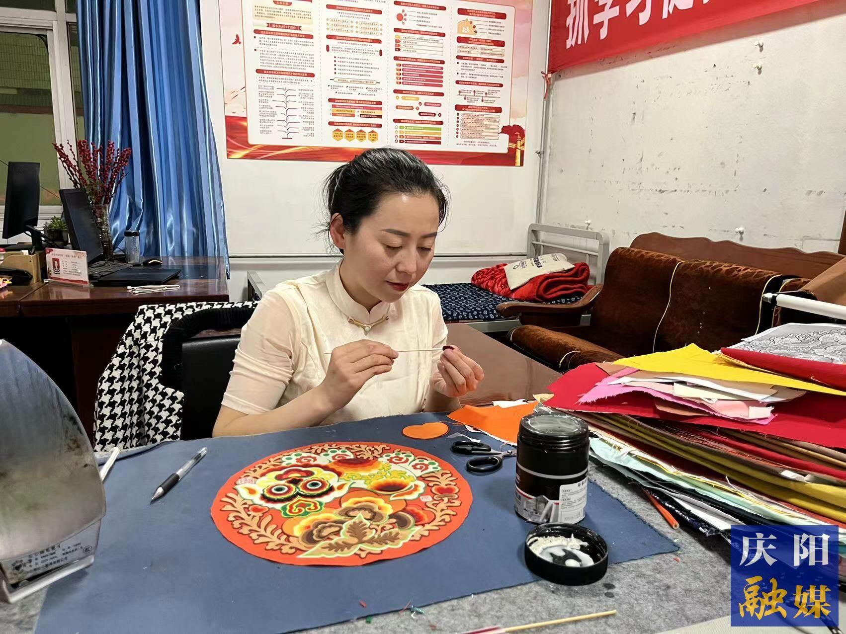 李慶英正在創(chuàng)作布貼畫作品。